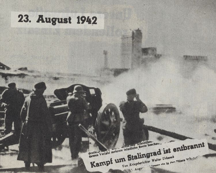 Eine Schwarz-weiß-Fotografie, auf der im Vordergrund vier Männer hinter einer Kanone zu sehen sind und Rauchschwaden im Hintergrund.