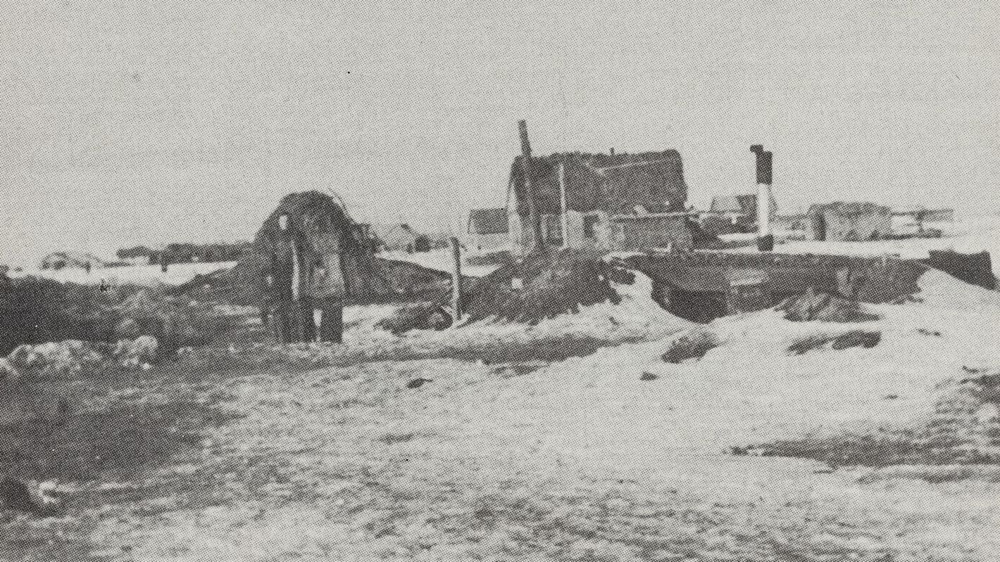 Eine Schwarz-weiß-Fotografie aus Stalingrad im Winter, auf der ein zerstörtes Haus und eine Person zu sehen sind.
