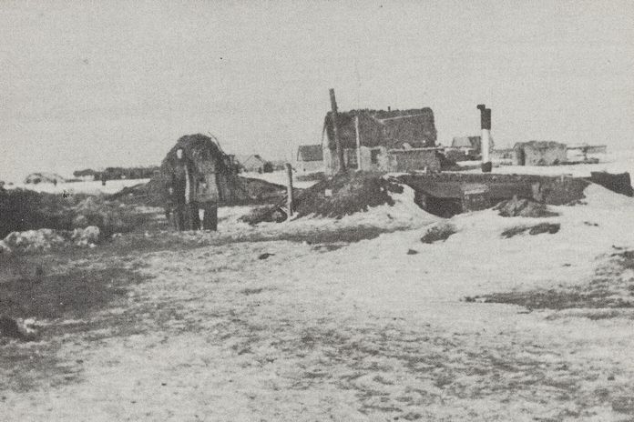 Eine Schwarz-weiß-Fotografie aus Stalingrad im Winter, auf der ein zerstörtes Haus und eine Person zu sehen sind.